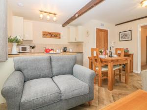 a living room and kitchen with a couch and a table at Hilly Field Barn in Yelverton