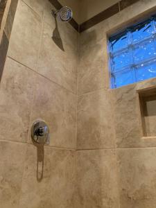 a shower with a shower head and a window at Villa Victoria in Valle de Guadalupe