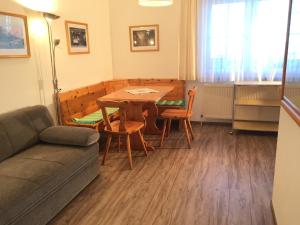 ein Wohnzimmer mit einem Tisch, Stühlen und einem Sofa in der Unterkunft Ferienwohnungen Kössl in Waidhofen an der Ybbs