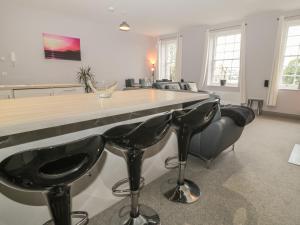 a kitchen with a bar with four black stools at The Sea Chest in Alnwick