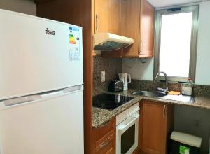 una cucina con frigorifero bianco e lavandino di Los Locos Beach Apartments a Torrevieja