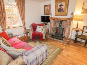 a living room with a couch and a fireplace at Chuckle Cottage in Northallerton