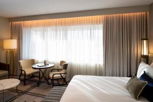 Una habitación de hotel con una cama, una mesa y sillas. en The William Inglis Mgallery, en Warwick Farm