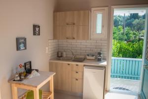 a kitchen with wooden cabinets and a sink and a window at Tsonas Apartments in Lygia