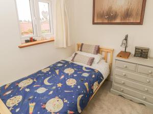 a small bedroom with a bed and a dresser at Chuckle Cottage in Northallerton
