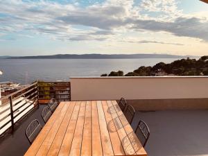a wooden table on a balcony with a view of the water at Berulia accommodation in Brela