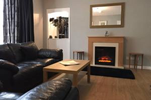 a living room with a couch and a fireplace at 1 Catherines City Cottage in Perth