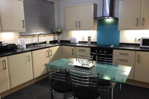 a kitchen with a glass table and chairs in it at 1 Catherines City Cottage in Perth +17 photos