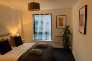 um quarto com uma cama grande e uma janela em Duke Street - Liverpool city centre apartment em Liverpool