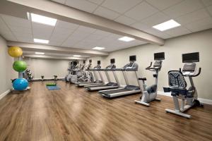 a gym with a row of treadms and cardio machines at Wyndham Newport Hotel in Middletown