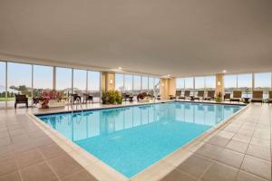 a large swimming pool in a hotel with windows at Wyndham Newport Hotel in Middletown