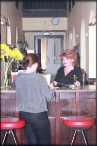 a woman standing at a counter in a barber shop at Hotel in in Amberg