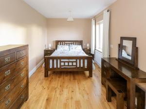 um quarto com uma cama, uma cómoda e um espelho em Clifftop Haven em Renvyle