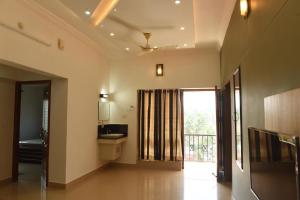 a room with a bathroom with a sink and a window at DOWN TOWN HOLIDAYS in Trivandrum