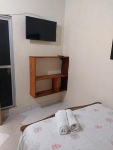 内科克利Hostal Princesa Katia的一间卧室配有带毛巾的床和平板电视
