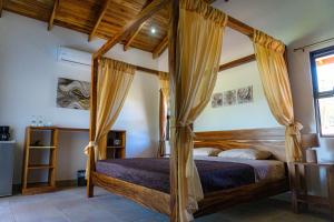 1 dormitorio con cama con dosel en una habitación en Hotel Casa Buenavista - Adults only, en Sámara