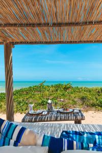 Hotel e Resort Villas de Trancoso في ترانكوسو: طاولة على الشاطئ مع إطلالة على المحيط