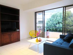 ein Wohnzimmer mit einem blauen Sofa und einem TV in der Unterkunft SAN JACINTO HOSTEL in Cartagena de Indias