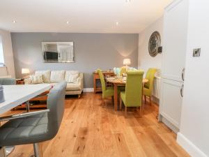 a kitchen and living room with a table and chairs at Grimsditch Dairy in Knutsford