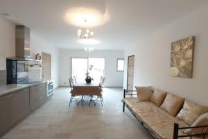 een woonkamer met een bank en een tafel en een keuken bij Les Prairies de l'Encrême in Céreste