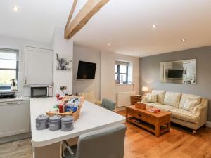 a kitchen and living room with a couch and a table at Grimsditch Dairy in Knutsford