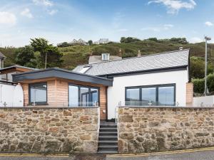 una casa con una pared de piedra en The Old Beach Store, en Sennen Cove