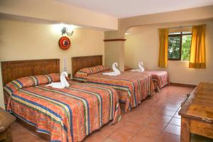 Cama ou camas em um quarto em Hotel Hacienda María Eugenia Acapulco