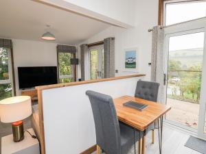 een eetkamer met een tafel en stoelen en een televisie bij 1 Valley View in Looe