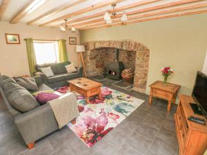ein Wohnzimmer mit Couch und Kamin in der Unterkunft Little Brook Cottage in Carmarthen