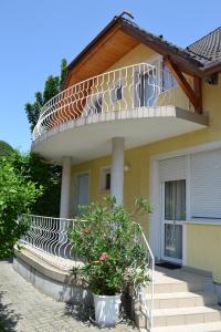 a house with a balcony on top of it at Atlantika Apartman in Balatonboglár