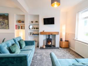 Twitcher's Rest في هارتلبول: غرفة معيشة مع أريكة زرقاء ومدفأة