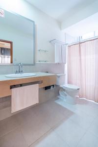 W łazience znajduje się umywalka, toaleta i lustro. w obiekcie Hotel y Suites Nader w mieście Cancún