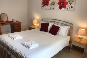 a bedroom with a large white bed with two night stands at 2 Catherines City Cottage in Perth