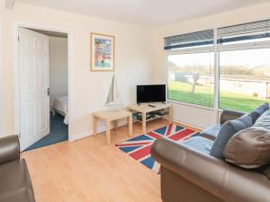 ein Wohnzimmer mit Sofa und Fernseher in der Unterkunft 304 Norton Park in Dartmouth