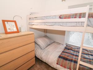 a bedroom with two bunk beds and a dresser at Yr Adfa The Retreat in Blaenau-Ffestiniog