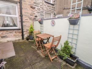 a wooden table and two chairs sitting next to a building at Yr Adfa The Retreat in Blaenau-Ffestiniog
