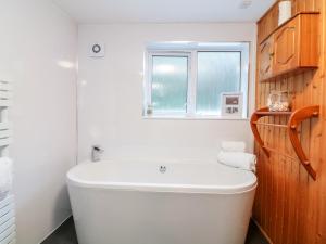 a bathroom with a white tub and a window at Polkirt Forge in Mevagissey +23 photos