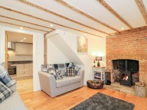uma sala de estar com um sofá e uma lareira em Tilly's Cottage em Westbury