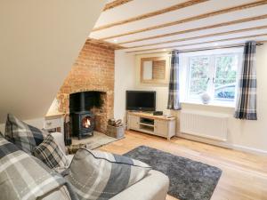 ein Wohnzimmer mit Couch und Kamin in der Unterkunft Tilly's Cottage in Westbury
