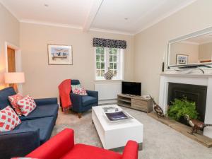 a living room with couches and a fireplace at South Tower Cottage in Macclesfield