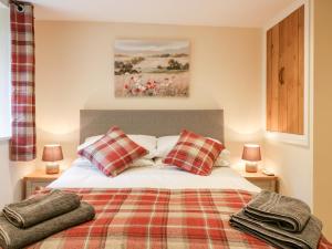 ein Schlafzimmer mit einem Bett mit zwei Kissen darauf in der Unterkunft Tilly's Cottage in Westbury