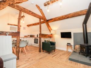 a kitchen and living room with wooden beams at Stabl, Plas Moelfre Hall Barns in Oswestry