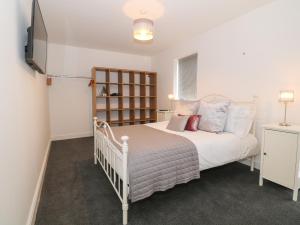 a bedroom with a bed and a television in it at 8 Marina View in Pwllheli