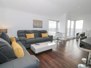 a living room with a couch and a table at 8 Marina View in Pwllheli