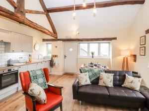 a living room with a couch and a table at Cut Moch, Plas Moelfre Hall Barns in Oswestry