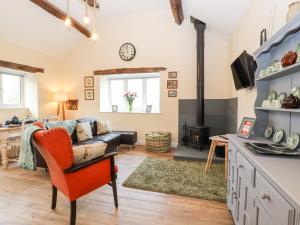 a living room with a couch and a fireplace at Cut Moch, Plas Moelfre Hall Barns in Oswestry