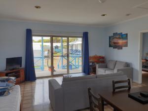 a living room with a couch and a table and a tv at Marion Bay Holiday Villas in Marion Bay