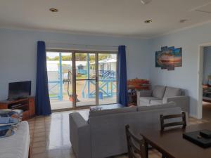 Una sala de estar con un sofá, una mesa y un televisor. en Marion Bay Holiday Villas, en Marion Bay