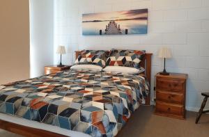 a bedroom with a bed and two night stands with lamps at Marion Bay Holiday Villas in Marion Bay