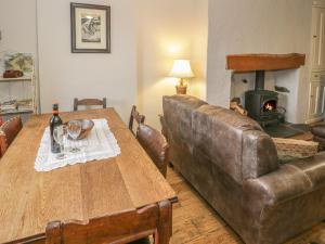 a living room with a table and a leather couch at Sygun View in Caernarfon